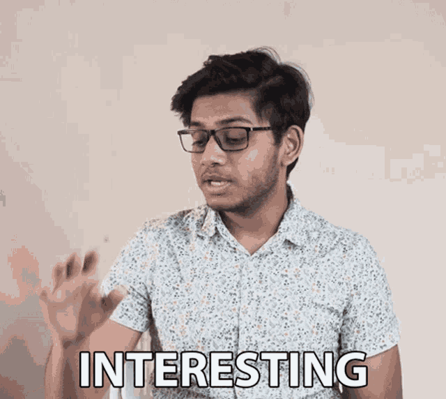 a man wearing glasses and a shirt that says interesting on it