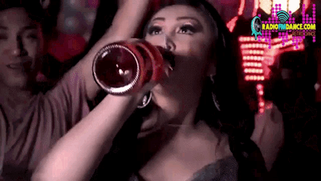 a woman drinking from a red bottle with a radiondance logo in the background