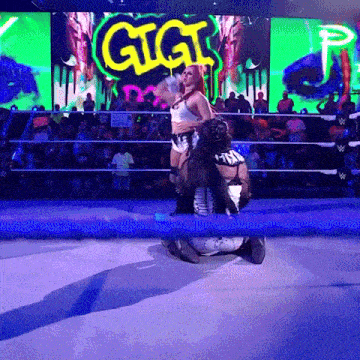 a woman in a wrestling ring with a sign that says gigi in the background
