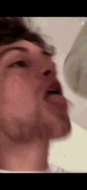 a man is sticking his tongue out in a blurry photo .