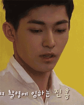 a close up of a young man 's face with korean writing on it