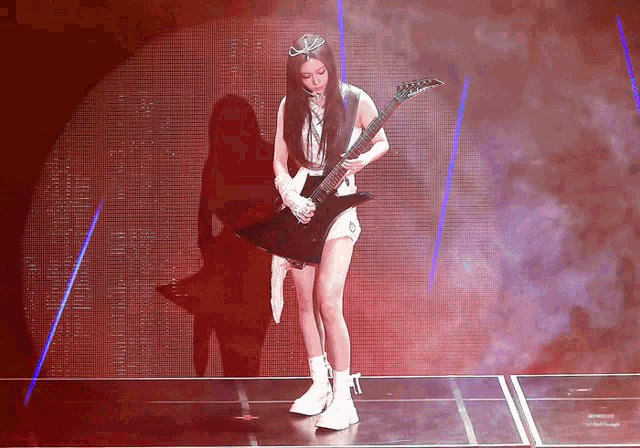 a woman with long hair is playing a guitar