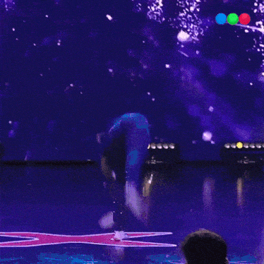 a person performing a trick on a stage with a star in the background