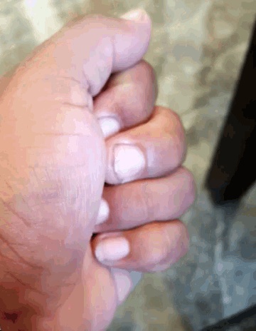 a close up of a hand with white nails