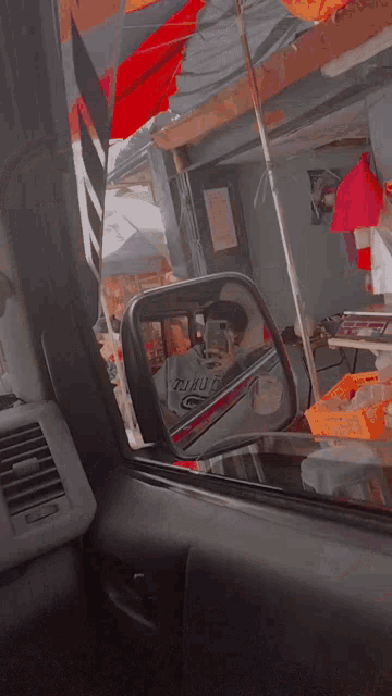 a person is taking a picture of their reflection in a car mirror