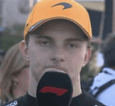 a man wearing a yellow hat is holding a microphone in front of his face .