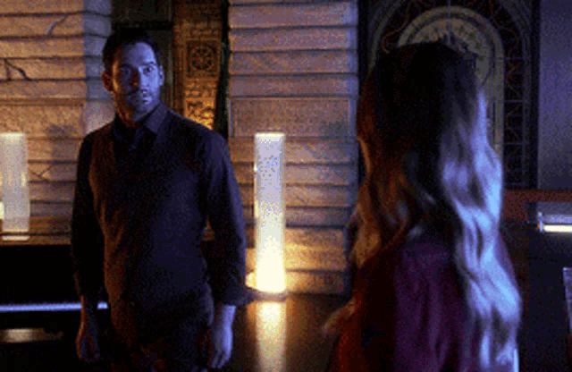 a man and woman are standing next to each other in a dark room .
