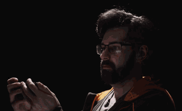 a man wearing glasses is clapping his hands in front of a black background that says my eyes