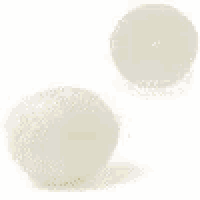 a green ball and a white ball are on a white surface .