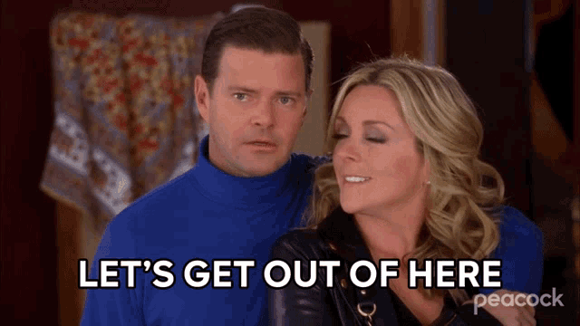 a man in a blue turtleneck stands next to a woman who says let 's get out of here on peacock