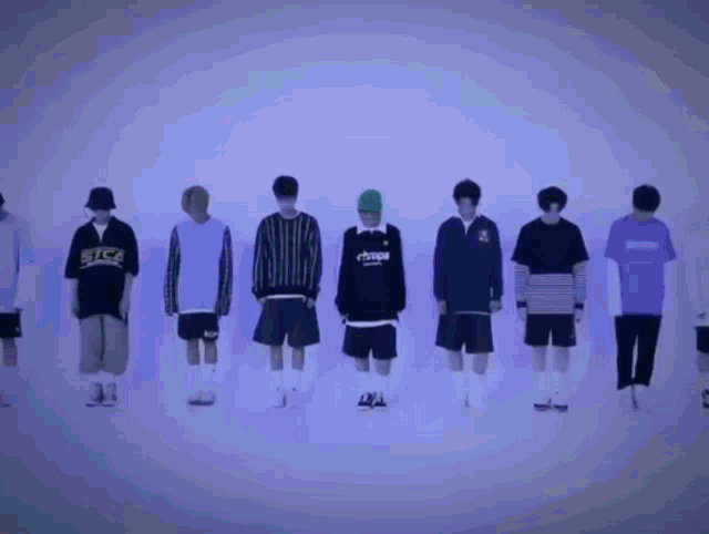 a group of young men are standing in a row with one wearing a sweatshirt that says ' ehmps '