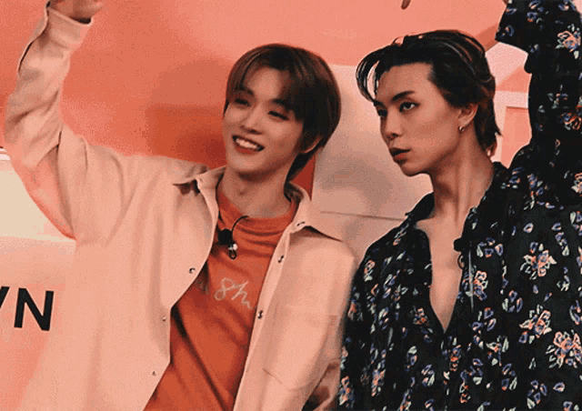 two young men are standing next to each other with one wearing an orange shirt that says 8h