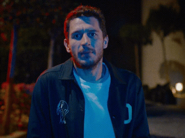 a man wearing a black jacket with the letter j on the back