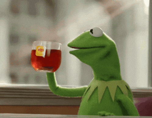 kermit the frog is holding up a cup of tea