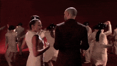 a group of people are dancing in a dark room