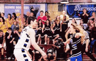 a basketball game is being played in front of a crowd with a banner that says ravens on it