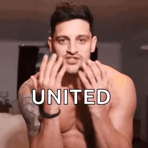 a shirtless man with a tattoo on his arm is making a united gesture with his hands .