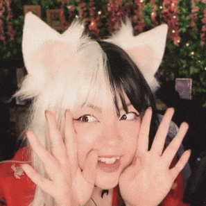 a woman wearing a cat ear wig is making a funny face .