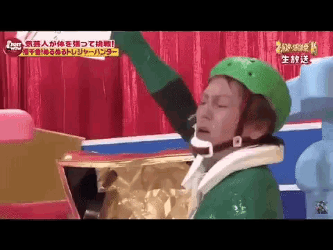 a man wearing a green helmet is standing in front of a box