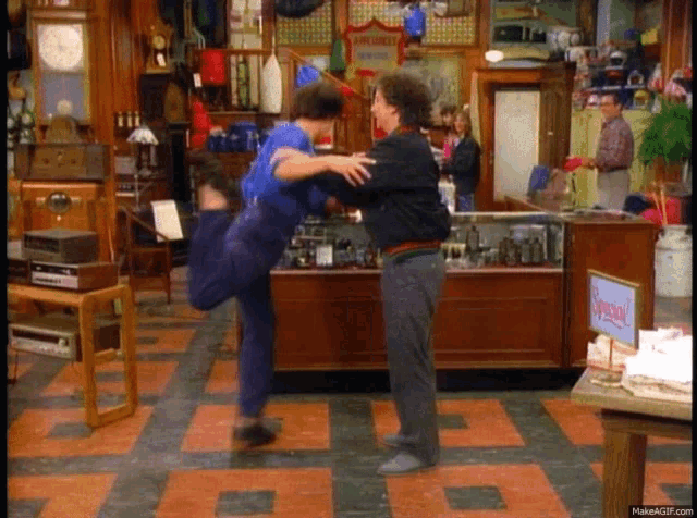a man is holding another man in his arms in a store