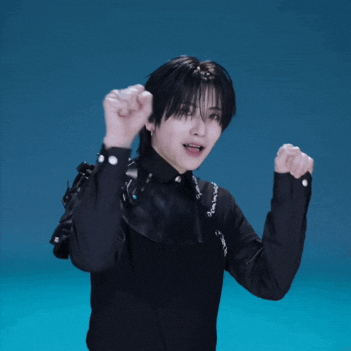 a man in a black shirt with chains around his neck is making a funny face