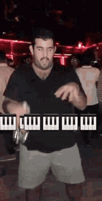 a man is dancing in a club while holding a bottle of beer .