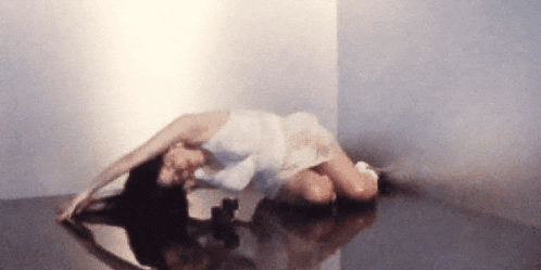 a woman in a white dress is laying on a table