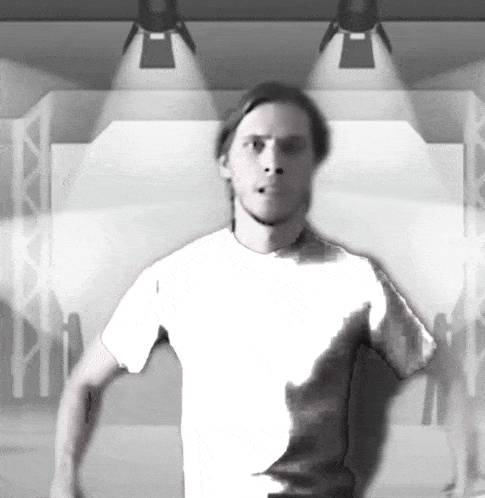 a man in a white shirt stands in front of a stage