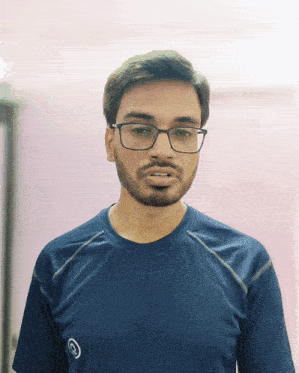 a man wearing glasses and a blue shirt has a circle on his shirt