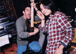 a man in a plaid shirt is holding a guitar