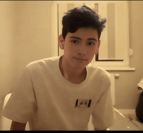 a young boy wearing a white t-shirt with the letter i on it