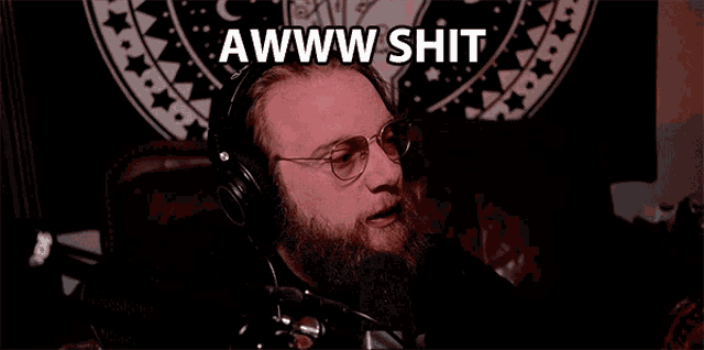 a man wearing headphones and glasses says awww shit in front of a tapestry
