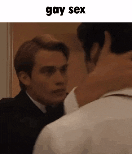 a man in a suit and tie is hugging another man in a room .