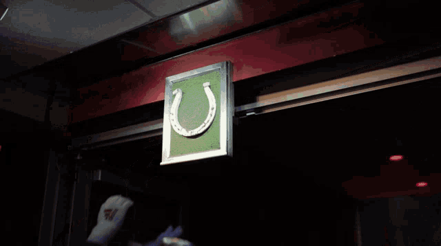 a sign with a horseshoe on it is being lifted up