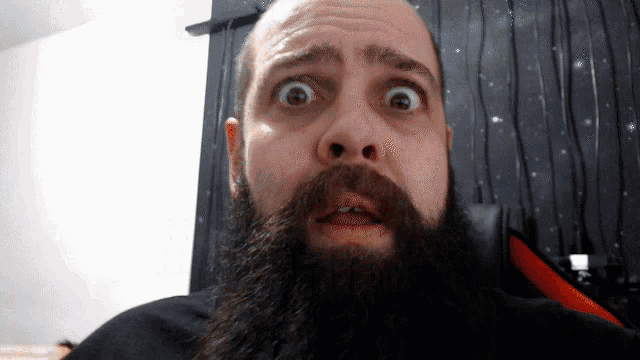 a bald man with a beard is making a funny face
