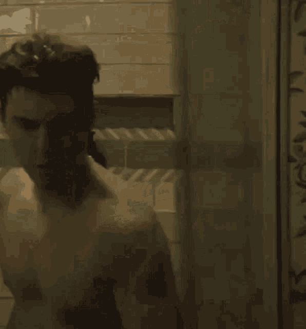 a man is taking a shower in a bathroom with a soap dispenser .