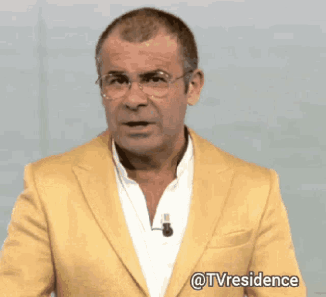 a man wearing glasses and a yellow jacket has the hashtag @tvresidence on the bottom right