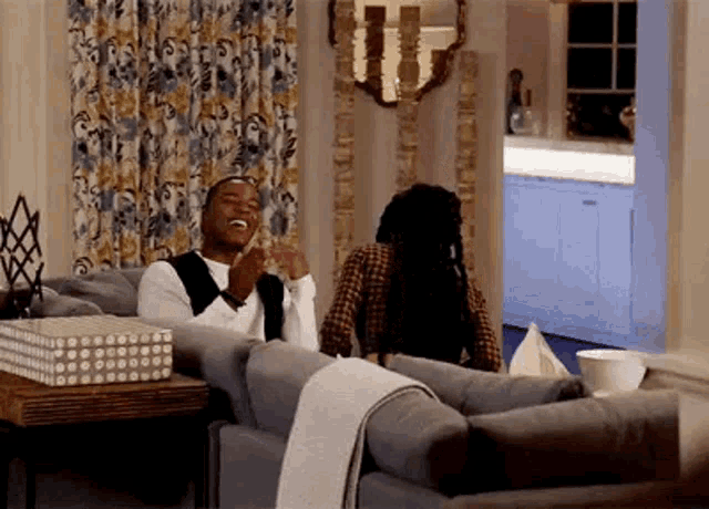 a man and a woman are sitting on a couch in a living room .