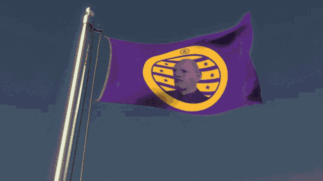 a purple and yellow flag with a picture of a man in the middle