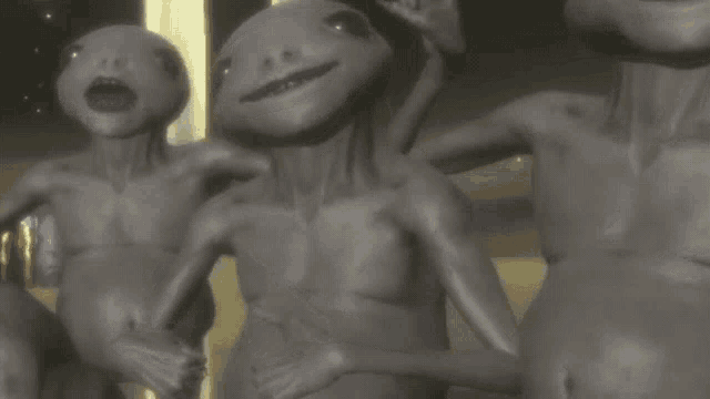 a group of aliens are standing next to each other and smiling