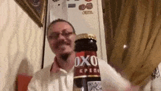 a man is holding a bottle of oxo beer in his hands .