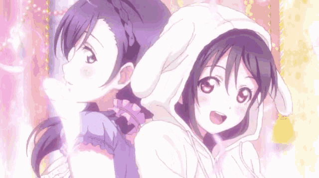 a couple of anime girls are standing next to each other . one of the girls is wearing a bunny hoodie .