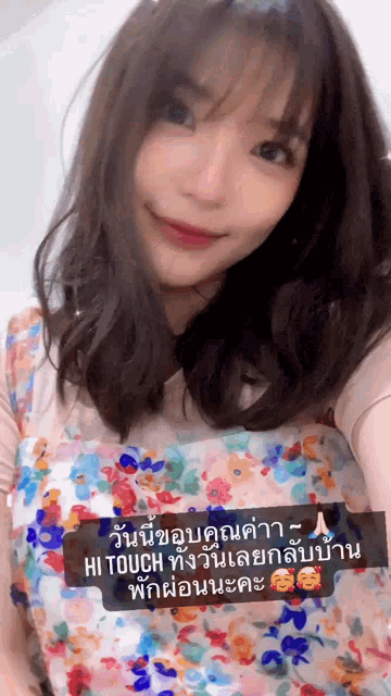 a woman is wearing a floral dress with a message in a foreign language that says hi touch