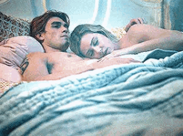 a man and a woman are laying in a bed .
