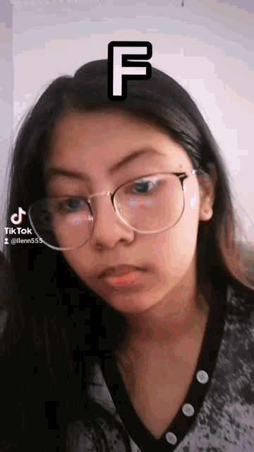 a girl wearing glasses has the letter f written on her face