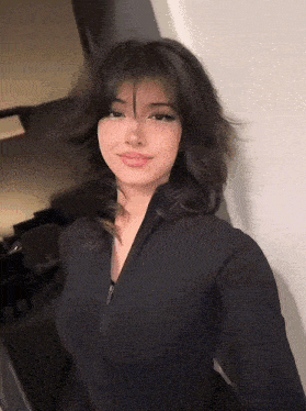 a woman in a black top is taking a selfie with her phone