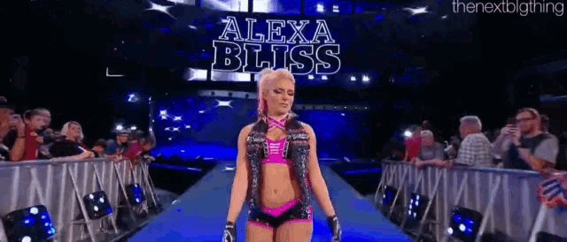 alexa bliss is walking down the aisle of a wrestling ring in front of a crowd .