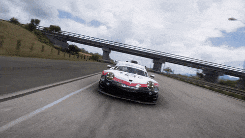 a race car with the number 44 on the front is driving under a bridge