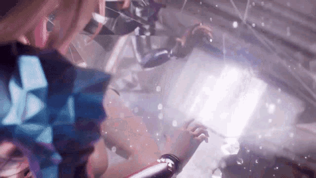 a woman is standing in a room with a purple light coming out of a window .
