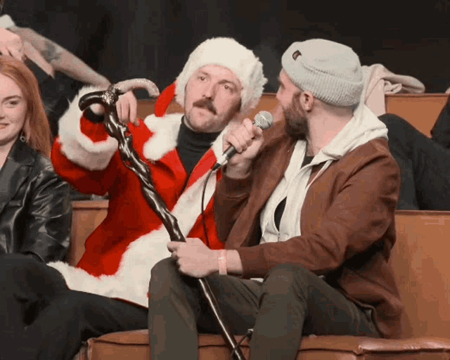 a man in a santa suit is holding a microphone